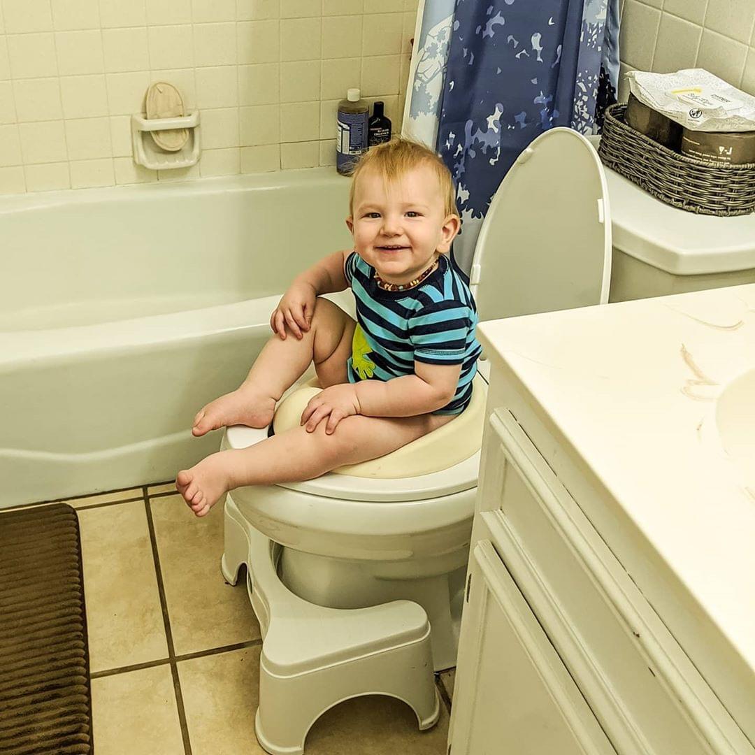 mama pottying baby over toilet