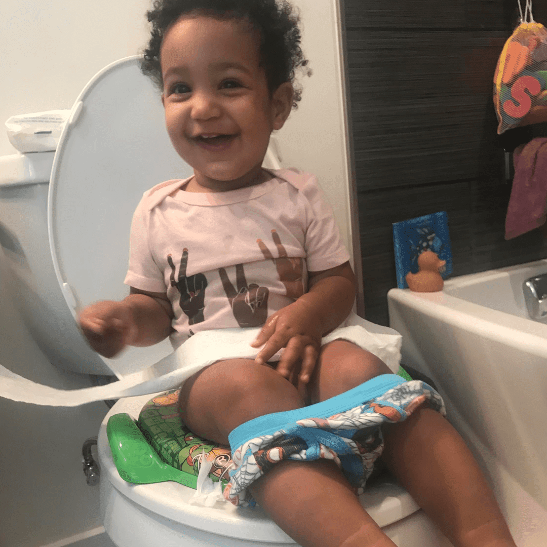 daddy pottying baby over toilet