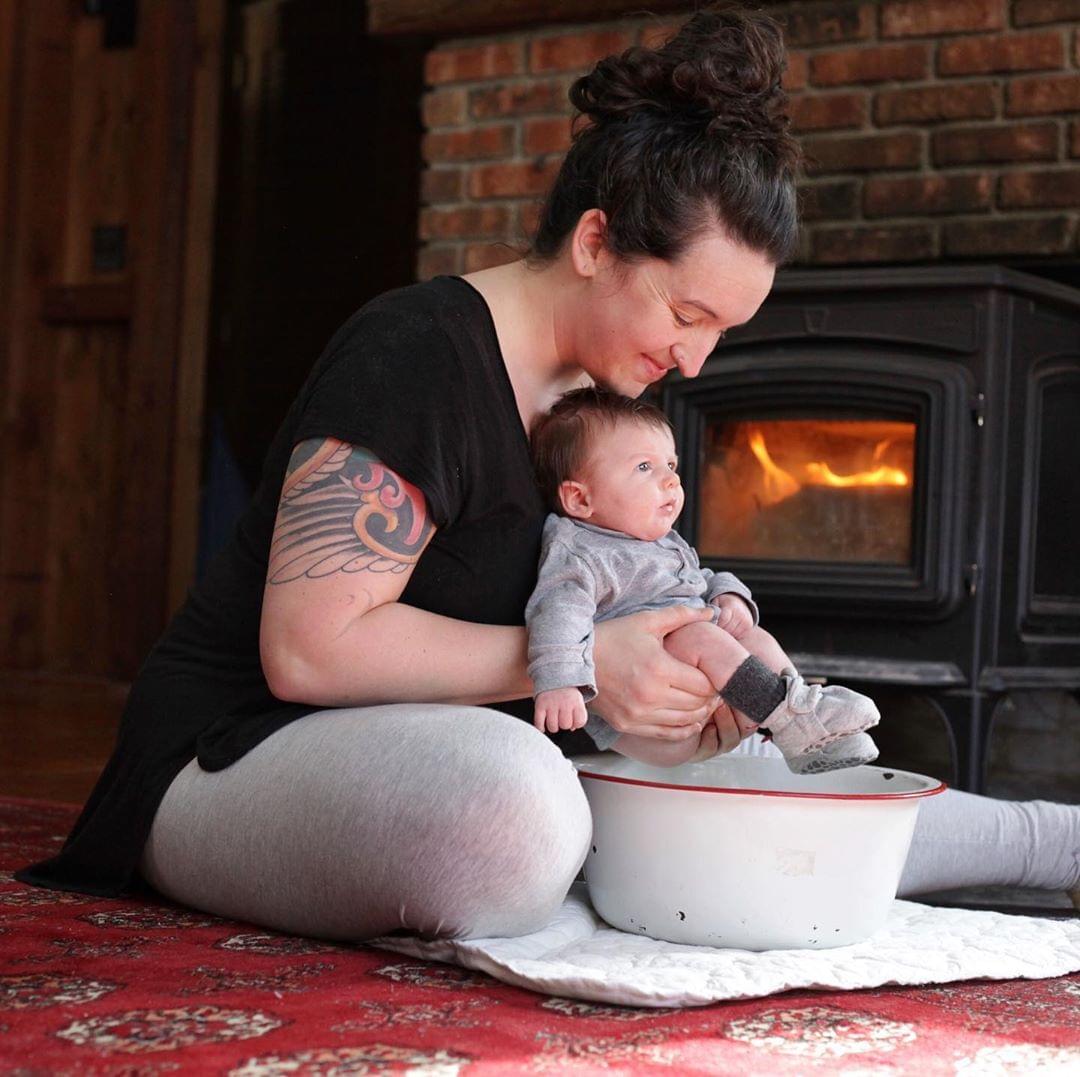 woman pottying baby over basin